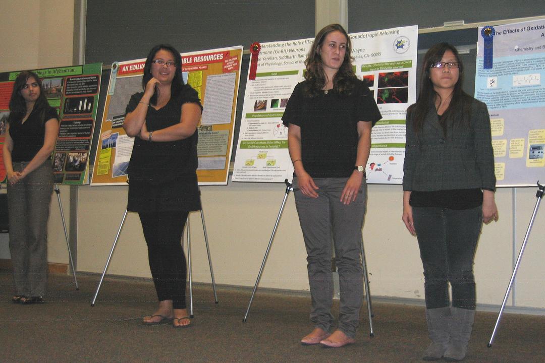 students posing in front of their presentations