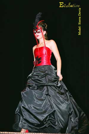 A Masquerade Ballroom Gown designed with a red satin corset, black satin skirt and a mask for the lovely lady.