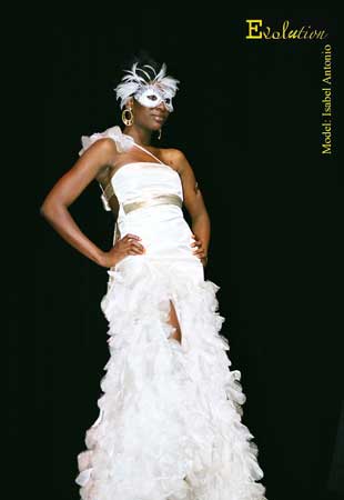 White gown with asymetrical shoulder strap, gold trim at high waist and side seams, long feather skirt and matching mask.