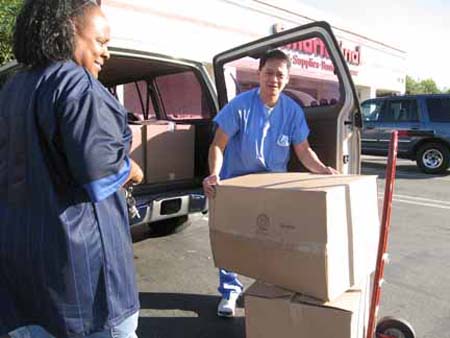 Arnold the Re-use Tech, helps bring boxes into dialysis center.