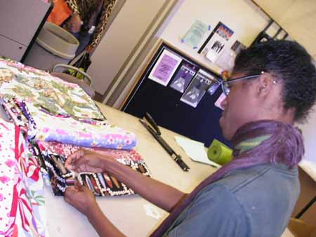 TM Club President helps with the stuffing of pillows.