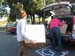 Fashion students help in bring boxes into cars.