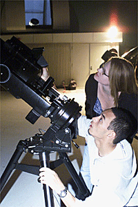 Students looking over a telescope