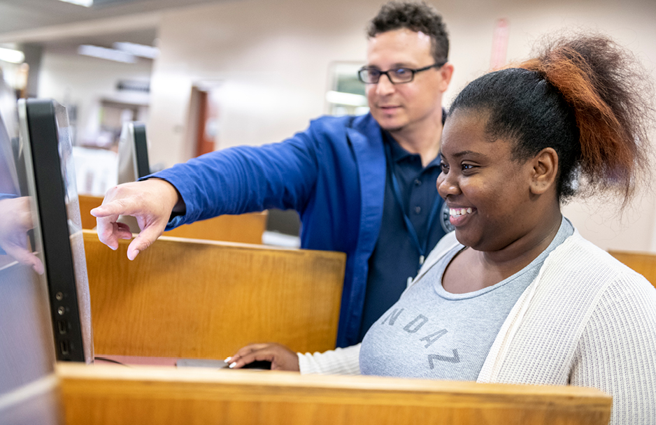 Librarian helping student at the computer