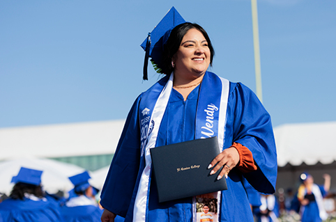 Graduate holding diploma and smiling