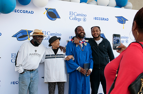 Grad posing for photo with friends and family