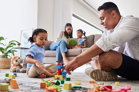 Child playing with block toys with parent.