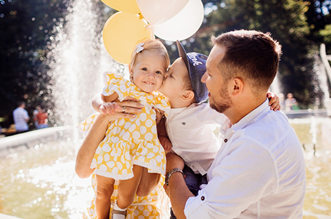 Smiling parent with child sitting on their shoulders