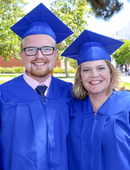 Mother and son graduates smiling at commencement.