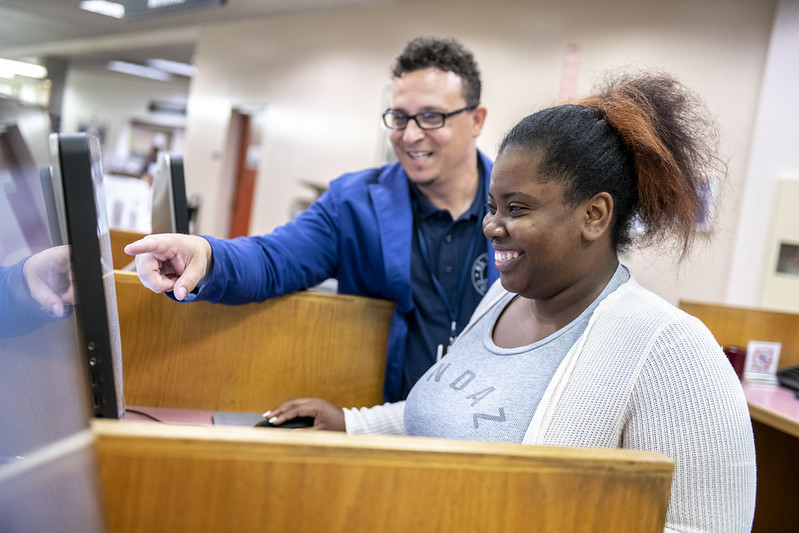 Library Faculty working with a Student at a computer