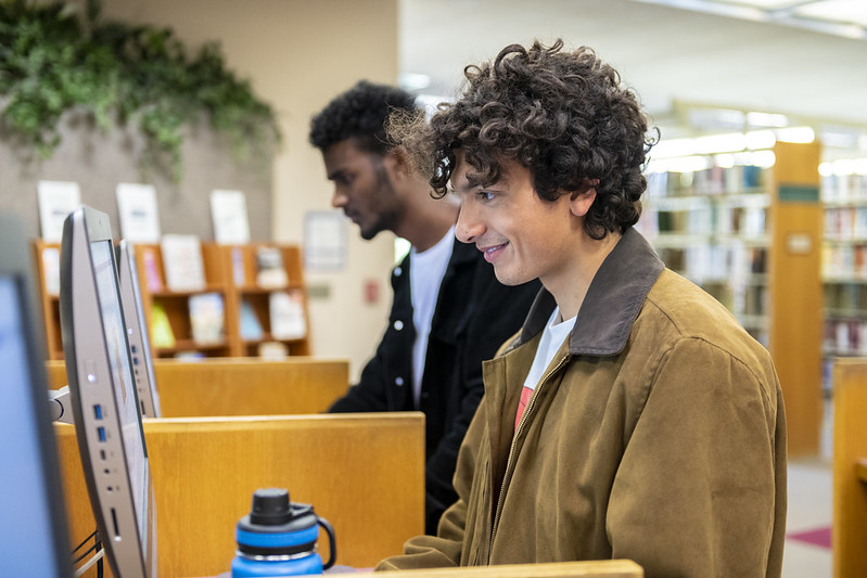 Two students standing at computers