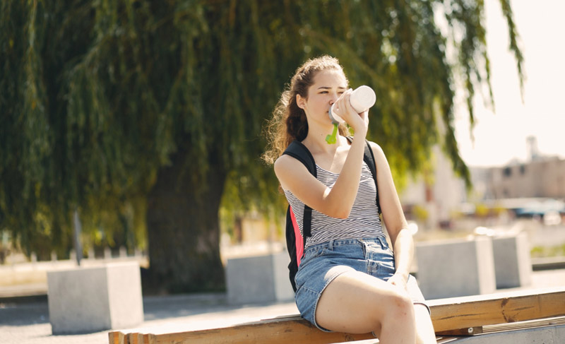Woman drinks from water bottle
