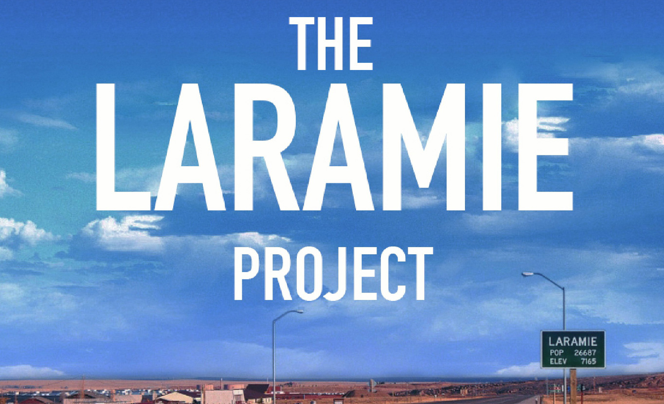 "The Laramie Project" in white text overlayed on a blue sky with clouds.