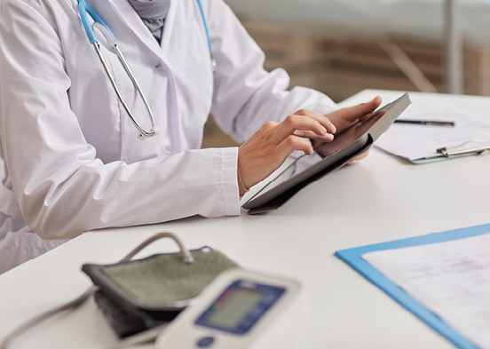 Nurse typing on tablet at a desk