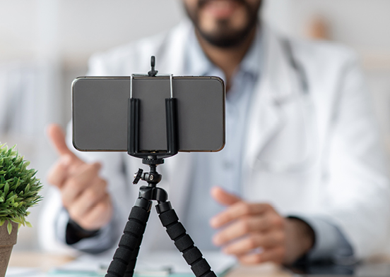 Nurse chatting on cell phone propped up on a small tripod