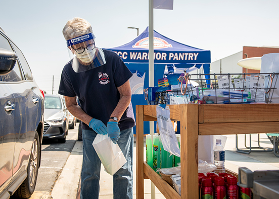 Volunteer handing out toiletries at the Warrior Pantry drive-thru